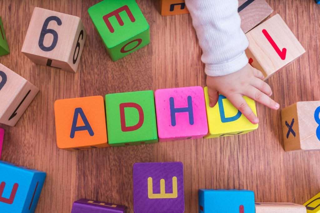 ADHD concept. Baby is playing with cubes with letters.