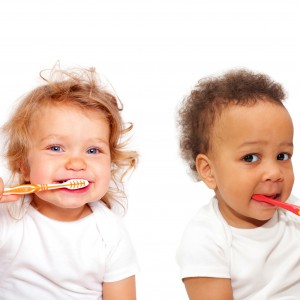Black and white baby toddlers brushing teeth. Isolated on white background.