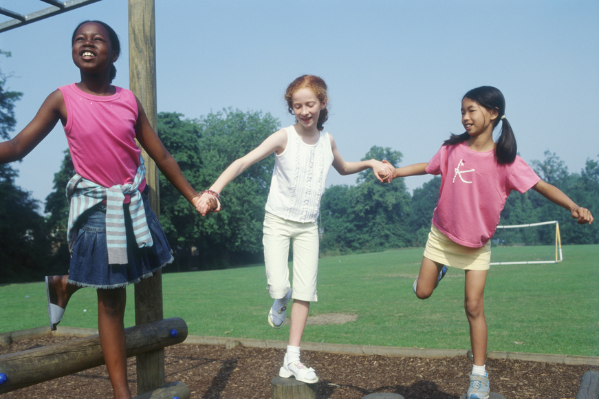 Three girls playing in park while holding hands