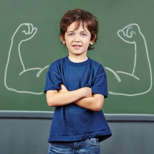 Strong child with muscles drawn on chalkboard in elementary school